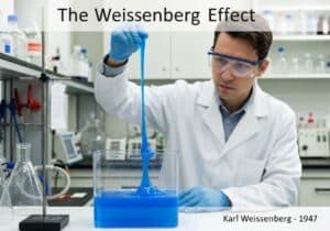 Chercheur démontrant l'effet Weissenberg avec un fluide viscoélastique dans un laboratoire.